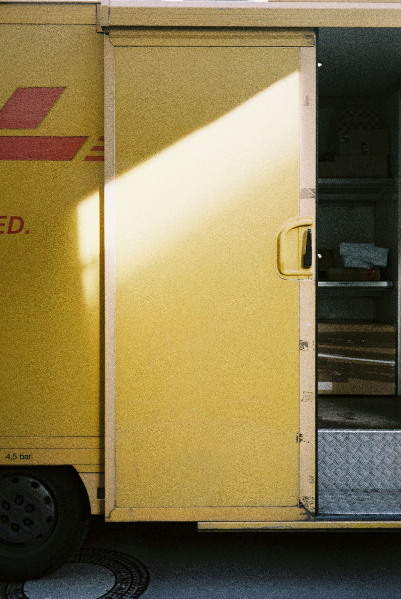 Camión de reparto amarillo con puerta lateral abierta